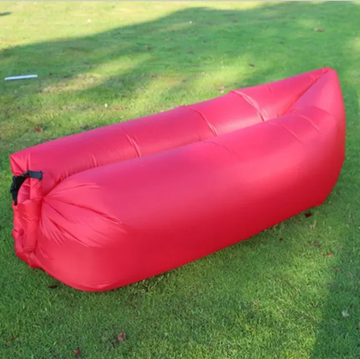 Canapé gonflable rouge, gonflé, posé sur l'herbe