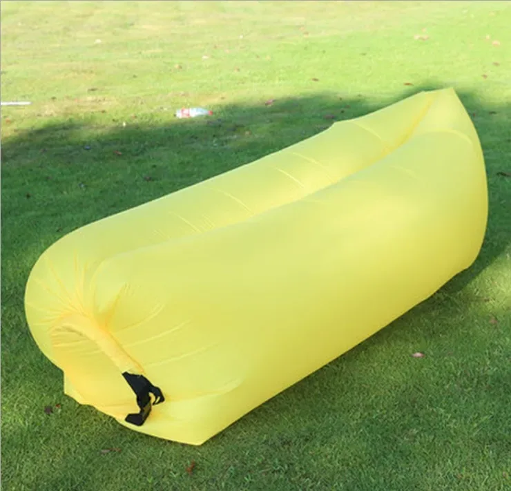 Canapé gonflable jaune, gonflé, posé sur l'herbe