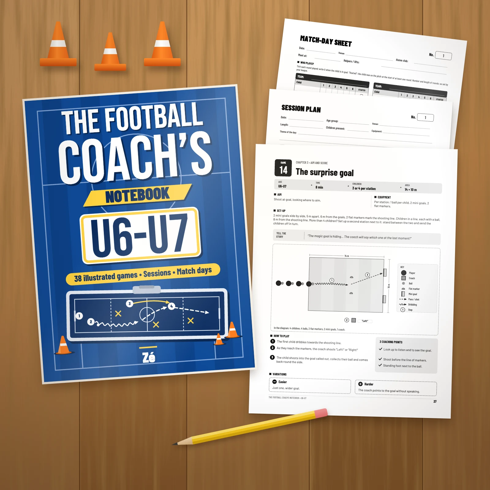The book on a wooden table next to three printed pages of the PDF: game 14 “The surprise goal”, a session plan and a match-day sheet, with a pencil and orange cones