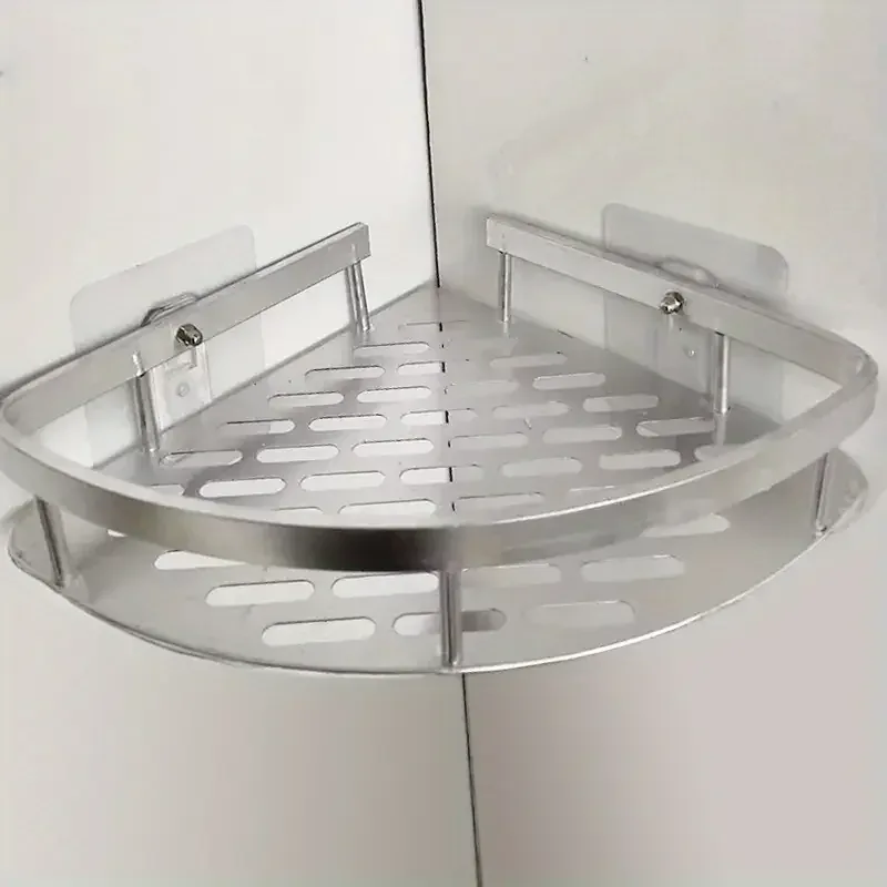 Étagère d'angle en aluminium argenté collée dans l'angle de deux murs carrelés, vue de face