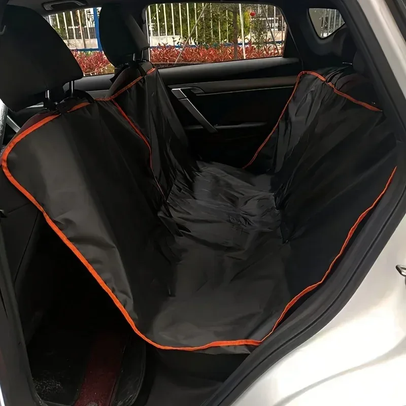 Housse de banquette arrière en tissu noir à liseré orange, installée dans une voiture, vue de l'intérieur
