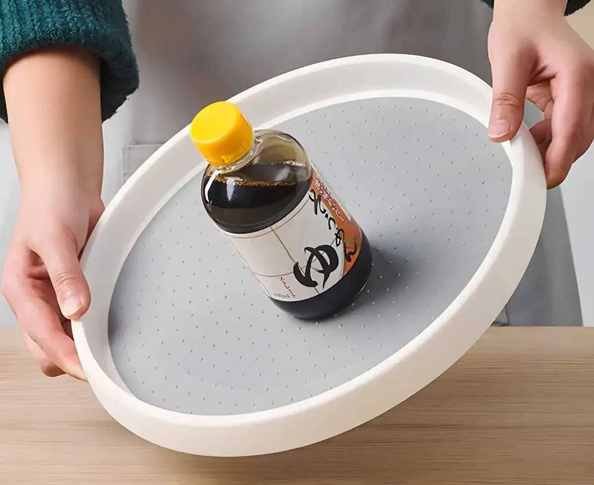 Mains qui soulèvent le plateau, avec une bouteille posée sur sa surface antidérapante