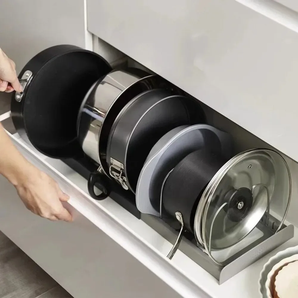 Casseroles, poêles et couvercles rangés à la verticale dans un tiroir de cuisine grâce au support