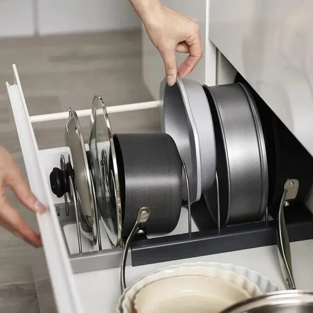 Main qui range un plat à four dans un support à grilles installé dans un tiroir de cuisine